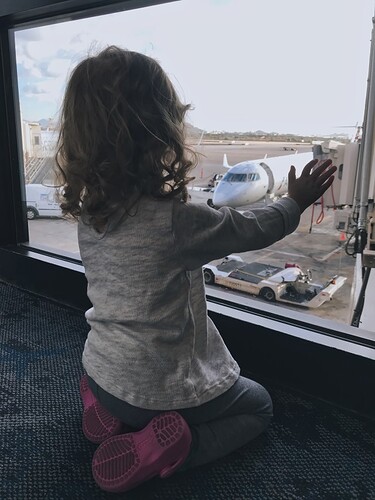 stock-photo-travel-window-airplane-hand-airport-watching-terminal-looking-out-little-girl-d7571dea-e439-4ecf-bf00-8875dd1bd658